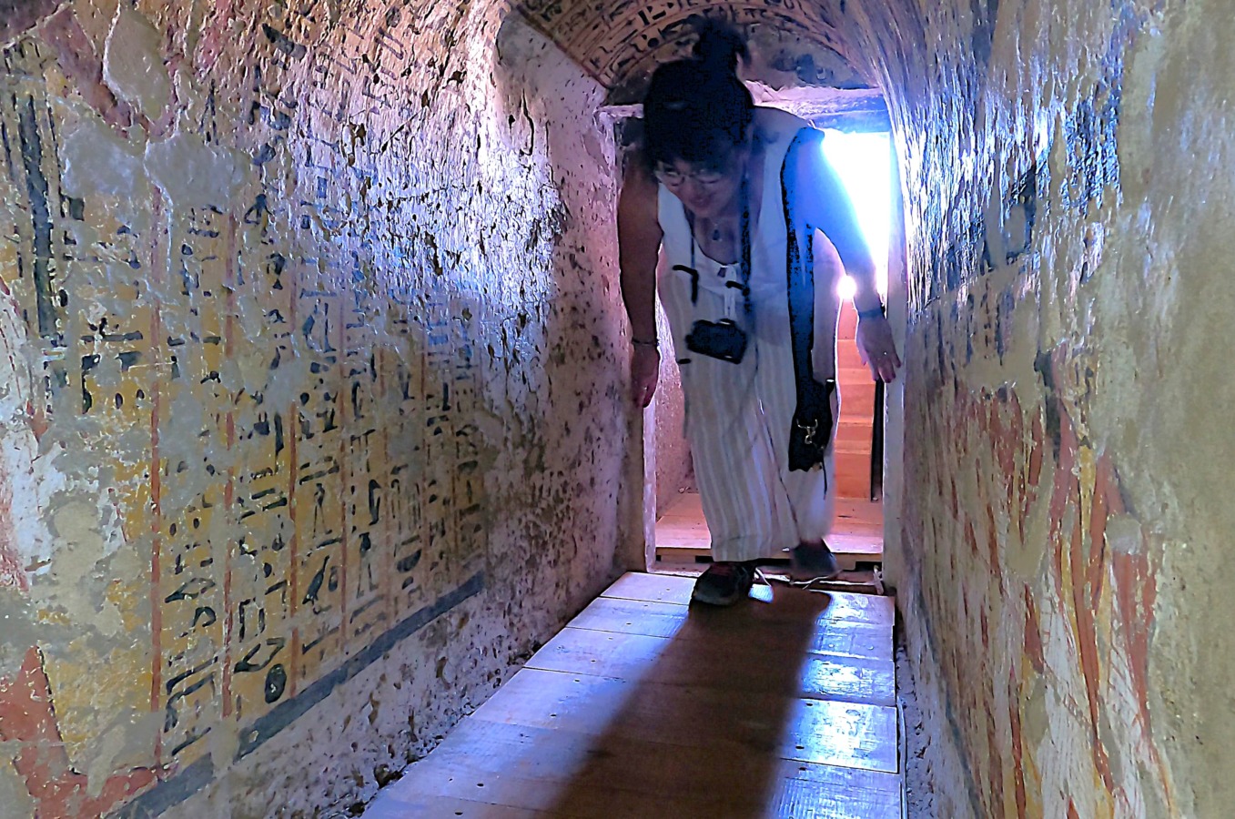 Pasando por el estrecho corredor de la entrada a las tumbas de la familia de Amun Nakht de Lúxor, Egipto.