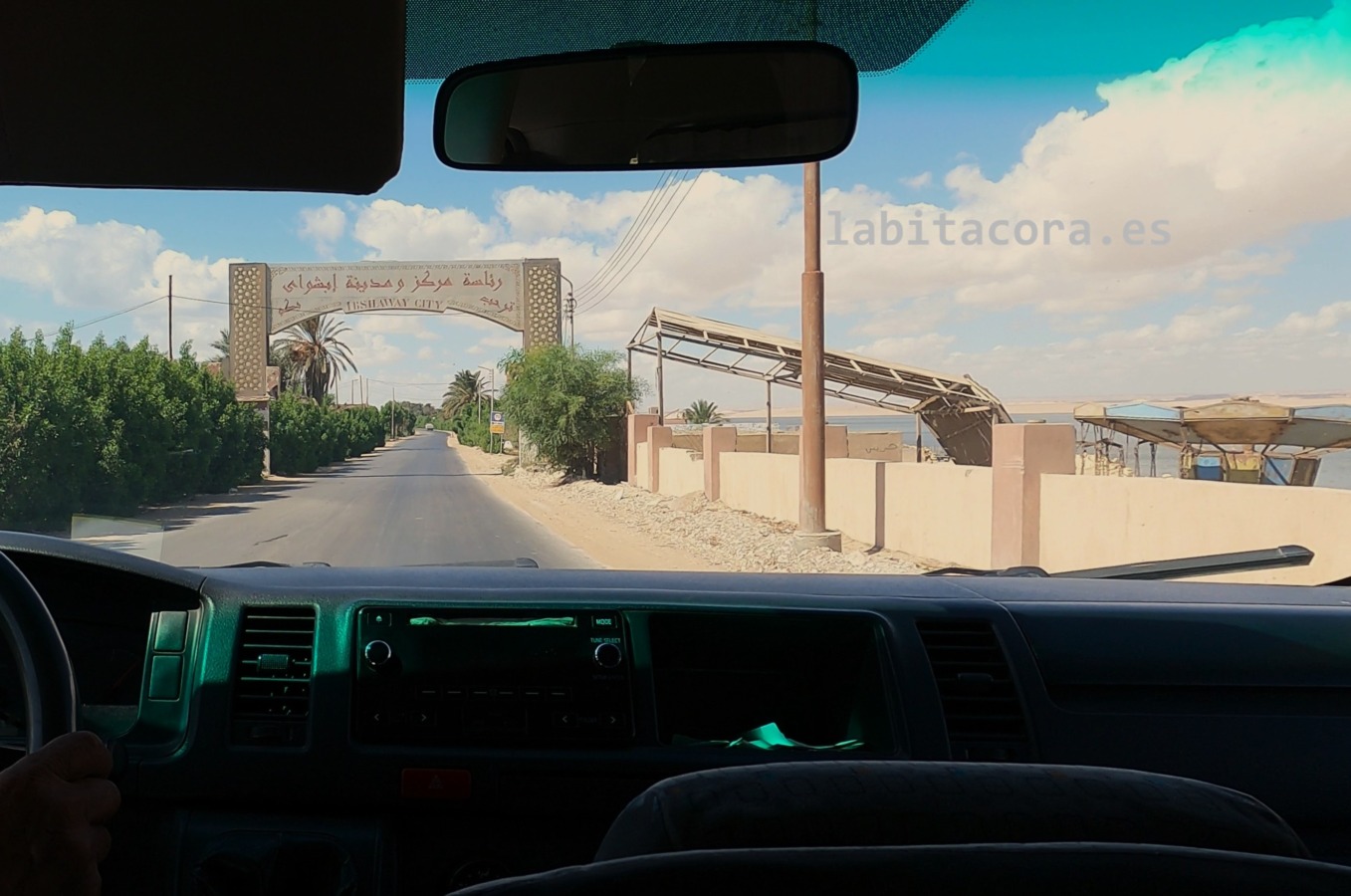 En la carretera, frente al arco de bienvenida de la ciudad de Ibshway, en el oasis de El Fayum, tras salir del Museo Kom Aushim. Egipto.